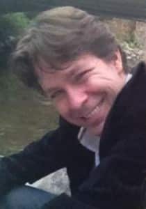 Literary agent Mark Malatesta sitting by a creek in Vail, CO